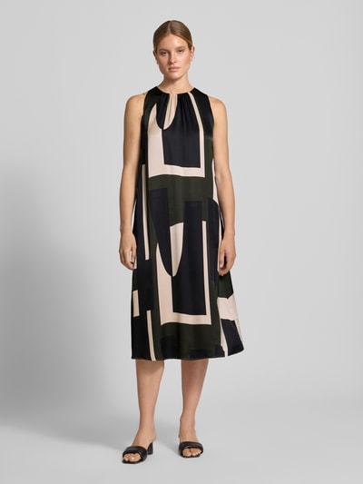 Frauenmodel trägt Midikleid aus reiner Viskose Modell 'Quileena' von someday, abstraktes Muster in Schwarz und Creme, lockere Passform, ärmellos, Rundhalsausschnitt, semitransparent, Ganzkörperansicht von vorne.