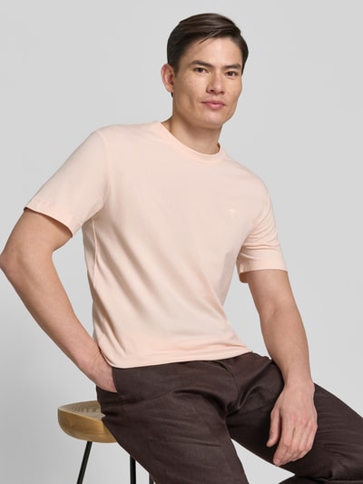 Männermodel trägt T-Shirt mit Rundhalsausschnitt Modell 'Carlonito' von JOOP! Collection, Baumwoll-Mix mit Stretch-Anteil, Straight Fit, Label-Detail, Rückenlänge bei Größe M 71 cm, sanfter Beigeton, glatte Textur, Ganzkörperansicht von vorne.