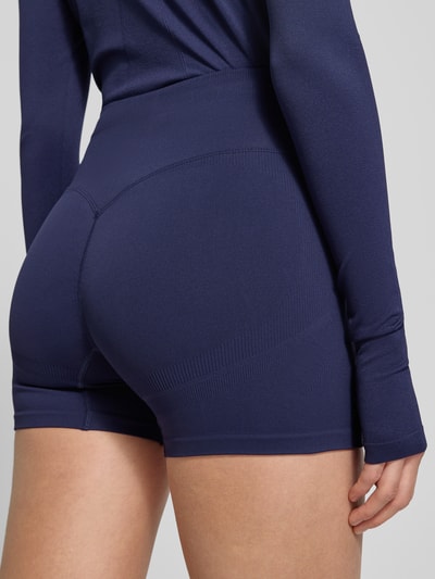 Frauenmodel trägt Slim Fit Shorts mit breitem Bund Modell 'Scrunch' von Fabletics aus Elastischer-Material-Mix in Dunkelblau, Detailaufnahme Rückansicht.