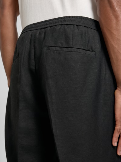 Männermodel trägt Shorts aus Leinen-Viskose-Mix Modell 'NEIL' von Antony Morato, schwarze Farbe, feine Struktur, Detailaufnahme Rückansicht, Herren Shorts, Regular-Fit, mit Bügelfalten und elastischem Bund, Bundweite 42 cm, Innenbeinlänge 17 cm, Größe 50.