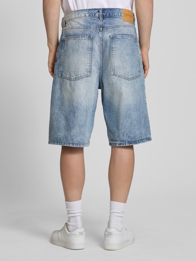 Männermodel trägt Jeansshorts im Used-Look mit Eingrifftaschen von REVIEW, relaxed fit, reine Baumwolle, Ganzkörperansicht Rückansicht.