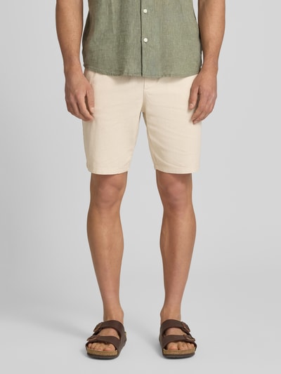 Männermodel trägt Regular Fit Shorts aus Baumwoll-Leinen-Mix Modell 'LINUS' von Only & Sons, Optik: Unifarben, Nahaufnahme Oberschenkel, Label-Applikation, Bundabschluss elastisch mit Tunnelzug, Eingrifftaschen, Gesäßtasche, helle Naturfarbe, leichte Struktur.