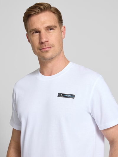 Männermodel trägt Regular Fit T-Shirt mit Logo-Applikation von Under Armour in Weiß, Rundhalsausschnitt, Baumwoll-Mix, Nahaufnahme Oberkörper.