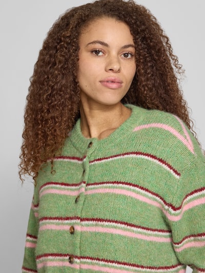 Frauenmodel trägt Cardigan mit Streifenmuster Modell 'CARO' von Topshop, Material-Mix mit Woll-Anteil, Relaxed-Fit, Rundhalsausschnitt, Knopfleiste, Nahaufnahme Oberkörper.
