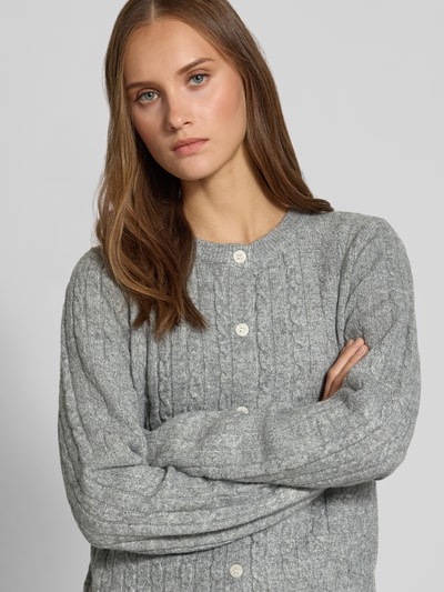 Frauenmodel trägt Regular Fit Strickjacke mit Woll-Anteil Modell 'SILLY' von PIECES in Hellgrau, Nahaufnahme Oberkörper, Damen Strickjacke.