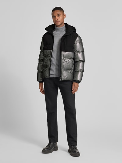 Männermodel trägt Regular Fit Steppjacke mit Stehkragen Modell 'ROYAL FLASH' von Wellensteyn in reflektierender Optik, Ganzkörperansicht von vorne.