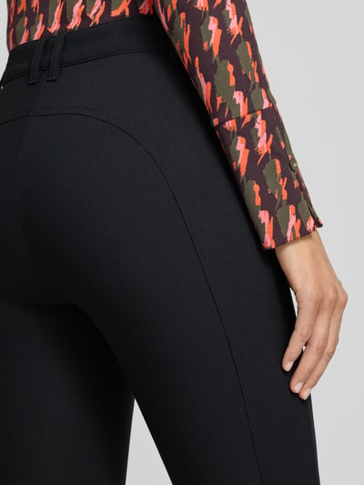 Frauenmodel trägt Slim Fit Schmale Hose mit Viskose-Anteil Modell 'SILEA' von Marc Cain in Schwarz mit Teilungsnähten, Nahaufnahme Rückansicht.