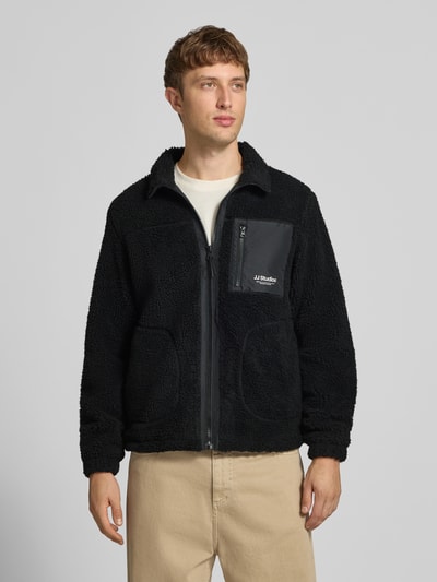 Mannenmodel draagt zwarte fleecejack met opstaande kraag Model 'SOHO' van JACK & JONES, Teddybont, regular fit, steekzakken, borstzak met ritssluiting, logo, ruglengte maat M 68 cm, mouwlengte maat M 69 cm, geheel aanzicht van voren
