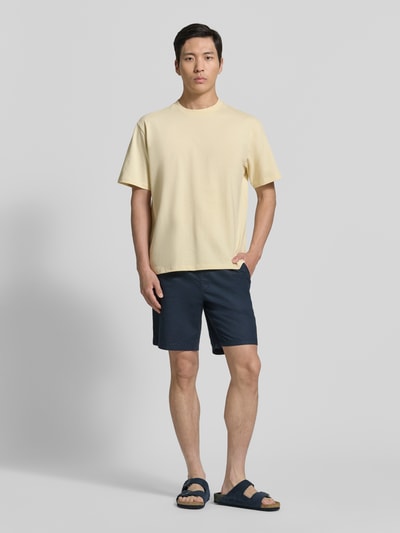 Männermodel trägt Oversized T-Shirt mit Rundhalsausschnitt von Lindbergh aus Reine Baumwolle, Label-Detail, sandfarben, Ganzkörperansicht von vorne.