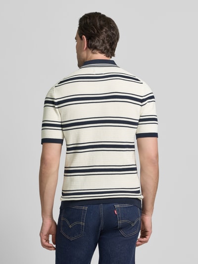 Männermodel trägt Slim Fit Poloshirt in Strick-Optik von MCNEAL, creme mit blauen Streifen, reine Baumwolle, Ganzkörperansicht Rückansicht.