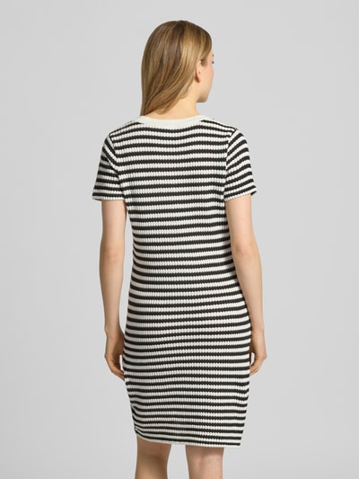 Frauenmodel trägt knielanges Strickkleid mit V-Ausschnitt Modell 'LORIANNA' von ICHI, Schwarz-Weiß-Streifen, Baumwoll-Mix, körpernah, Ganzkörperansicht Rückansicht.