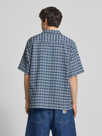 Männermodel trägt Regular Fit Freizeithemd aus reiner Baumwolle von Carhartt Work In Progress, kariertes Strukturmuster, Ganzkörperansicht Rückansicht.