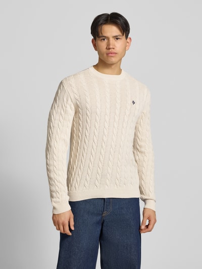Männermodel trägt Strickpullover mit Zopfmuster und Logo-Stitching von REVIEW aus Baumwoll-Mix, Modern Fit, Rundhalsausschnitt, Ganzkörperansicht von vorne.