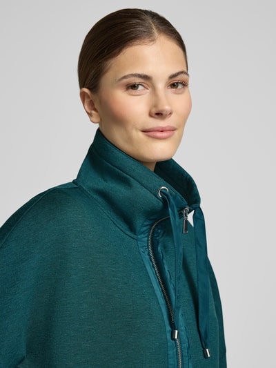 Vrouwenmodel draagt Boxy Fit Sweatjacke met Viskose-Anteil van Tom Tailor, effen kleur, scuba textuur, 3/4-mouw, staande kraag, detailopname bovenlichaam.