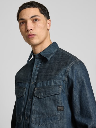 Männermodel trägt Regular Fit Jeanshemd mit Brusttaschen Modell 'Dakota' von G-Star Raw aus Reine Baumwolle, Nahaufnahme Oberkörper.