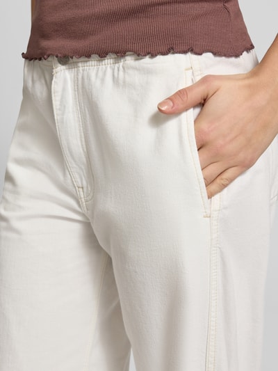 Frauenmodel trägt Wide Leg Jeans mit Tunnelzug von Guess Jeans aus Baumwoll-Lyocell-Mix in Creme, Nahaufnahme Oberkörper, Bundweite 40 cm, Innenbeinlänge 79 cm, sichtbarer Knopf- und Reißverschluss sowie Tunnelzug, Damen Jeans-Look.