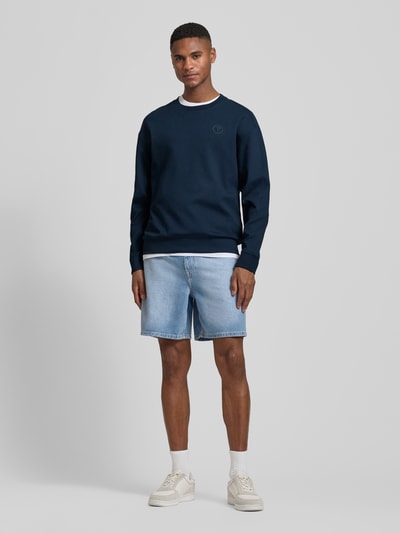 Männermodel trägt dunkelblaues Sweatshirt mit Label-Patch Modell 'Juanfrancisco' von JOOP! Collection, Baumwoll-Mix, Ganzkörperansicht von vorne