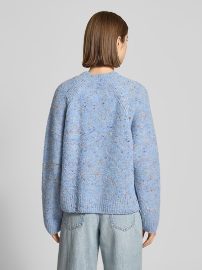 Vrouwenmodel draagt Oversized Strickjacke aus Schurwoll-Mix van Marc O'Polo in meerkleurig effen look, abstract motief, geribde mouw- en rompzoom, ronde hals, oversized pasvorm, knoopsluiting, grof gebreide textuur, detailopname rugaanzicht.
