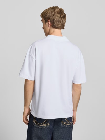 Männermodel trägt Boxy Fit Poloshirt aus Baumwoll-Mix Modell 'CASPIAN AIRLEX' von Only & Sons, weiß, Uni, Label Patch, Ganzkörperansicht Rückansicht.