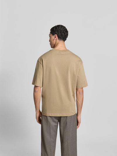 Männermodel trägt Relaxed Fit T-Shirt aus reiner Baumwolle von ANNARR in Beige mit kurzen Ärmeln und Rundhalsausschnitt, Rückenansicht.