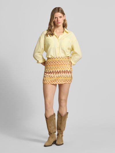 Frauenmodel trägt Minirock im Stufen-Look von Gina Tricot in buntem Zickzack-Muster, Material-Mix mit Stretch-Anteil, elastischer Bund, A-Linie, Bundweite bei Größe S: 30 cm, Gesamtlänge bei Größe S: 37 cm, Ganzkörperansicht von vorne.