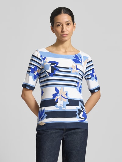 Modelka nosi T-Shirt aus Viskose-MIx mit Rundhalsausschnitt von Betty Barclay, damski t-shirt, mieszanka wiskozy i elastanu, taliowany krój, okrągły dekolt, rękaw o dł. 1/2, długość tyłu w rozmiarze 36: 59 cm, wzór w niebieskie pasy i abstrakcyjne kwiaty, widok całej sylwetki od przodu.