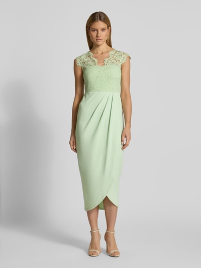 Frauenmodel trägt Midikleid mit Spitze Modell 'CLARA' von Vila in Mintgrün, taillierter Schnitt, V-Ausschnitt, Ganzkörperansicht von vorne.