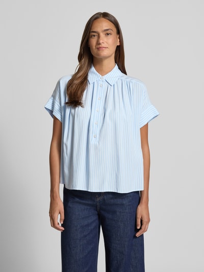 Frauenmodel trägt Relaxed Fit Bluse aus Viskose Modell 'Zafine' von Someday, hellblau gestreift, Hemdblusenkragen, Knopfleiste, Rückenlänge 63 cm, Ganzkörperansicht von vorne.