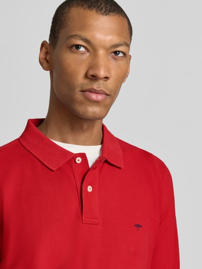 Männermodel trägt Regular Fit Langarm-Poloshirt mit Label-Stitching von Fynch-Hatton in Rot, reine Baumwolle, Nahaufnahme Oberkörper.