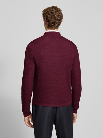 Männermodel trägt Regular Fit Strickjacke aus reiner Schurwolle von Emporio Armani, bordeauxrot, feine Strickstruktur, Rückenansicht, Herrenmode