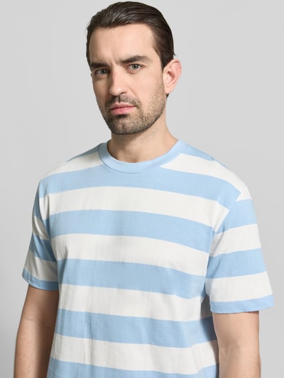 Männermodel trägt Oversized T-Shirt mit Rundhalsausschnitt von Lindbergh aus reiner Baumwolle im blauen und weißen Streifenmuster, Nahaufnahme Oberkörper.