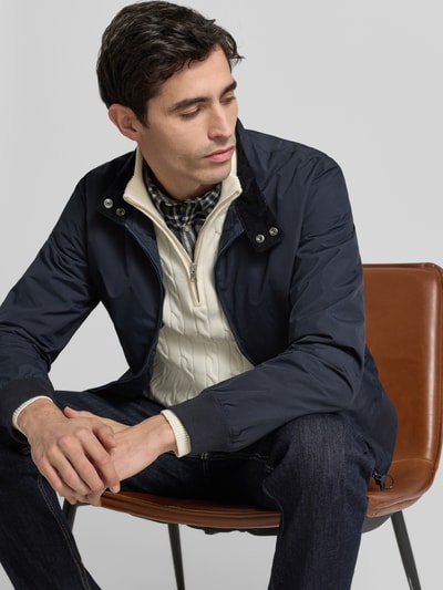 Męskiko model nosi Regular Fit Bluzon mit Stehkragen Model 'Royston' od Barbour, efekt: jednolity kolor, stójka, zamek błyskawiczny dwustronny, z napisem z logo, otwory wentylacyjne, długi rękaw, prążkowane zakończenia, boczne kieszenie zapinane na zamek, kieszenie wewnętrzne; zdjęcie: ujęcie górnej części ciała z przodu.
