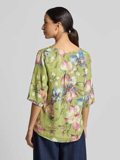 Vrouwenmodel draagt linnen blouse van zuiver linnen Model 'Rileyy' van ZABAIONE, groene kreuklook met bloemendessin, halflange mouwen, los model, ruglengte maat S 64 cm, mouwlengte maat S 38 cm, ronde hals. Ganzkörperaanzicht achteraan.