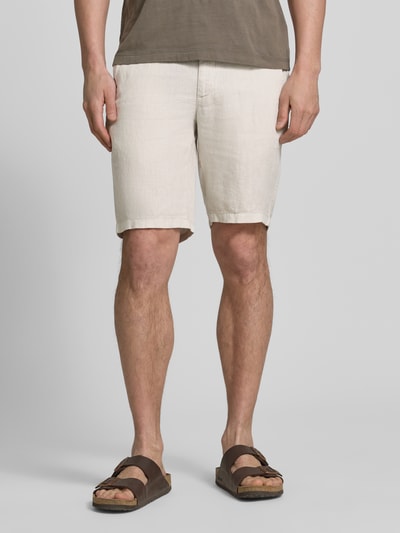 Męski model nosi Regular Fit Bermuda aus reinem Leinen od Brax, efekt: jednolity kolor, krój regular fit, szlufki na pasek, zapięcie na guzik i ukryty zamek błyskawiczny, wpuszczane kieszenie, materiał: len, jasny beż, gładka tekstura, widok całej sylwetki z przodu.