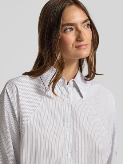 Kobiece modelka nosi bluzkę z krótkim rękawem z bawełny Relaxed Fit model 'C_BELENTA' od BOSS Orange, delikatne paski, jasne kolory, zbliżenie na górną część ciała