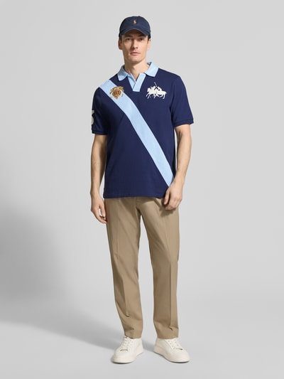 Männermodel trägt Regular Fit Poloshirt aus reiner Baumwolle von Polo Ralph Lauren in Two Tone Optik mit Logo-Stitching, Ganzkörperansicht von vorne.