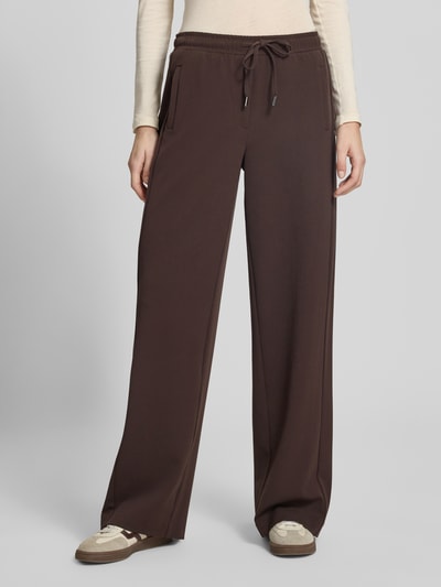 Kobiece modelka nosi Hose mit elastischem Bund Modell 'Melane flow' von OPUS, krój regular fit, materiał z domieszką wiskozy, szerokość w rozmiarze 36: 39 cm, długość nogawki od wewnątrz: 81 cm, ciemnobrązowy kolor, widok całej sylwetki z przodu