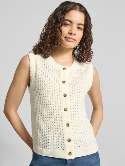 Modelka nosi Slim Fit Strickweste aus Baumwoll-Mix von Marc O'Polo DENIM w kolorze kremowym, złote guziki, tekstura ażurowa, kamizelka dzianinowa, damska, mieszanka bawełny, zdjęcie całego ciała z przodu.