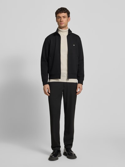 Männermodel trägt Regular Fit Sweatjacke mit Logo-Stitching von Emporio Armani, Schwarz, Baumwoll-Mix, Stehkragen, Eingrifftaschen, Zweiwege-Reißverschluss, elastische Abschlüsse, Ganzkörperansicht von vorne.