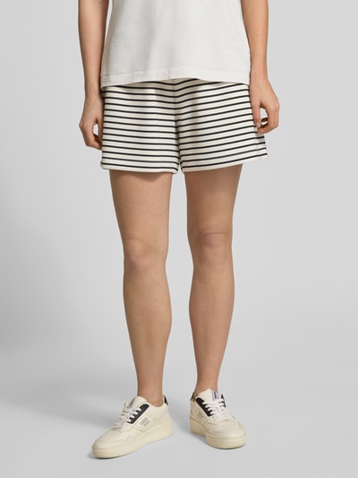 Kobiece model prezentuje szorty z wpuszczanymi kieszeniami od Jake*s Casual, mieszanka modalu z dodatkiem streczu, wysoki stan, elastyczny pas z trokiem, szerokość w rozmiarze S: 39 cm, długość wewnętrzna nogawki w rozmiarze S: 13 cm, stylizacje casualowe, biało-czarne paski, tekstura gładka, widok całej sylwetki z przodu.