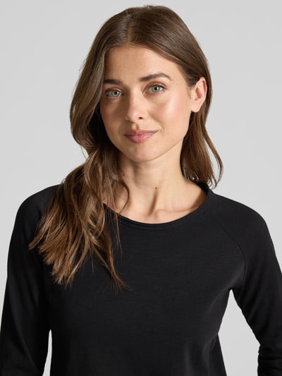 Frauenmodel trägt Longsleeve mit Rundhalsausschnitt und Rollsaum von Smith and Soul aus reiner Baumwolle im Regular-Fit, schwarze Farbe, Nahaufnahme Oberkörper.