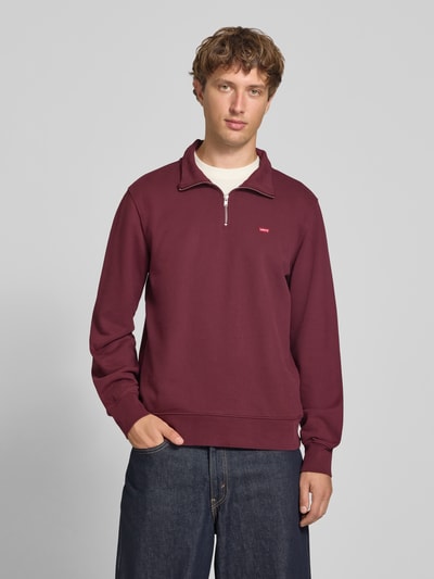 Männermodel trägt Regular Fit Pullover aus reiner Baumwolle von Levi’s®, bordeauxrot, glatte Oberfläche, Ganzkörperansicht von vorne. Herren Pullover von Levi's®.