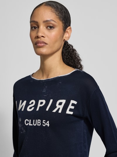 Frauenmodel trägt Longsleeve mit Linksdruck und Rundhalsausschnitt von monari, reine Baumwolle, Regular Fit, dunkelblau mit weißem Aufdruck, Nahaufnahme Oberkörper.