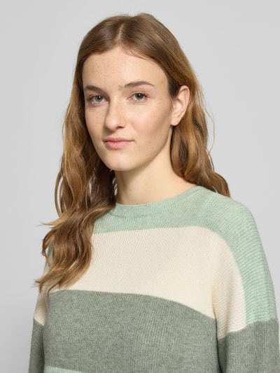 Frauenmodel trägt Regular Fit Strickpullover aus Viskose-Mix Modell 'ATIA' von Only, mehrfarbig gestreift, Nahaufnahme Oberkörper.