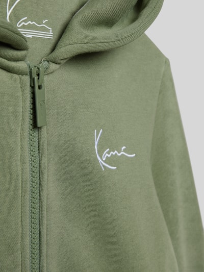 Produktfoto, sweatjack met steekzakken van KARL KANI van katoenmix in olijfgroen met capuchon en ritssluiting, los model, detailopname