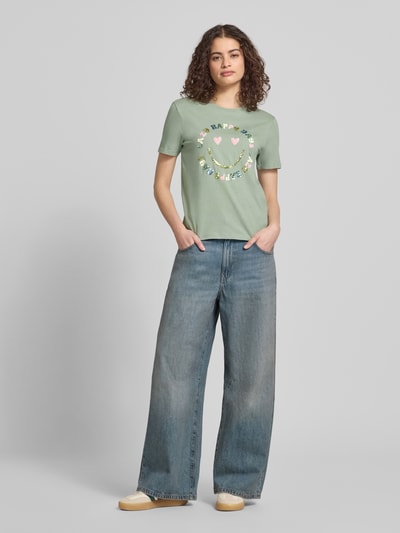 Kobiece modelka nosi Regular Fit T-Shirt aus reiner Baumwolle Modell 'KITA' od Only, jednolity kolor, z motywem, cekiny, okrągły dekolt, krótki rękaw, jersey, przód na wysokości całej sylwetki