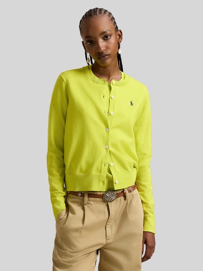 Frauenmodel trägt Regular Fit Strickjacke mit Logo-Stitching von Polo Ralph Lauren in Gelb, Rundhalsausschnitt, Knopfleiste, Nahaufnahme Oberkörper.