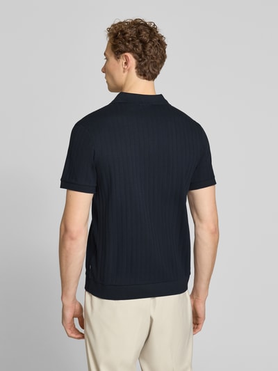 Męski model nosi Regular Fit Poloshirt mit V-Ausschnitt Modell 'Baronito' von JOOP! Collection z bawełny, fakturowany wzór, długość tyłu 69 cm, kolor ciemnogranatowy, Ganzkörperansicht Rückansicht.