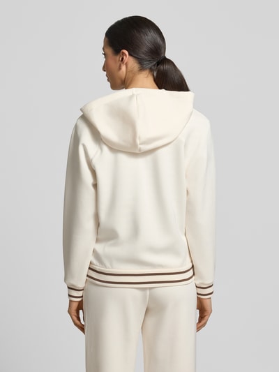 Frauenmodel trägt Regular Fit Sweatjacke aus Viskose-Mix mit Logo-Stitching von ARMANI EXCHANGE, cremefarben, elastische Abschlüsse, Kapuze mit Tunnelzug, Reißverschluss, Ganzkörperansicht Rückansicht.