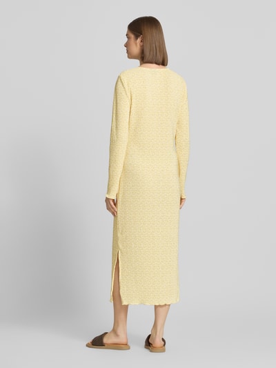 Frauenmodel trägt Tailliertes Freizeitkleid mit Allover-Muster Modell 'FLORA' von Pieces in zartem Gelb mit floralem Muster, Crinkle-Textur, Ganzkörperansicht Rückansicht.